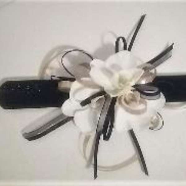 White flower corsage with black ribbon on a wristband