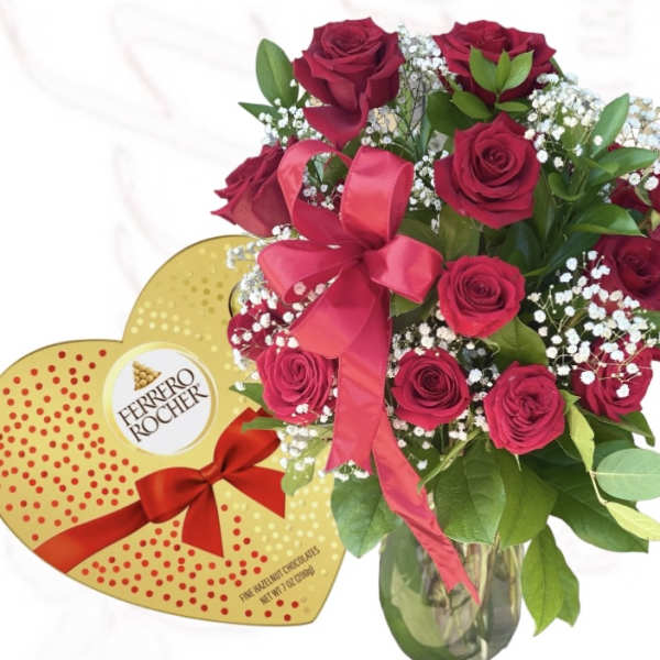 Bouquet of red roses in a glass vase beside a heart-shaped chocolate box
