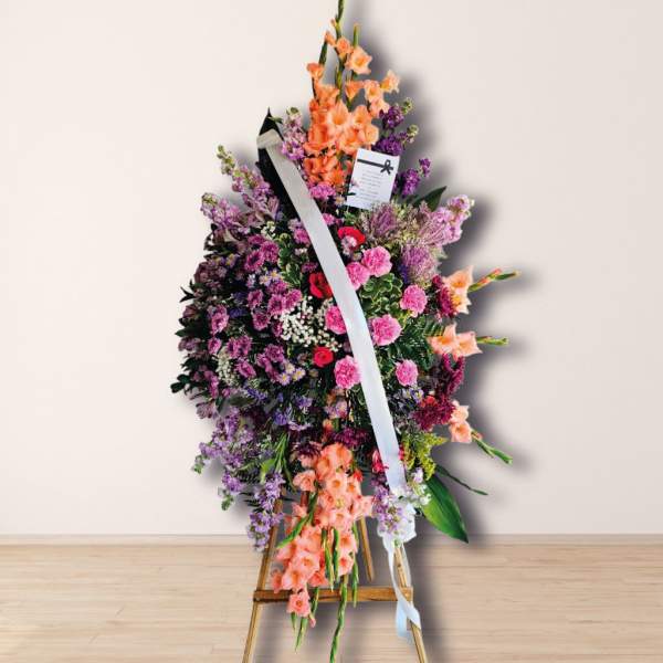 Standing floral spray with pink, purple, and peach flowers on an easel