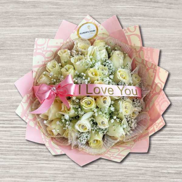 Bouquet of cream roses with a pink ribbon and "I Love You" band