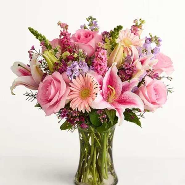 Pink roses and lilies in a clear glass vase