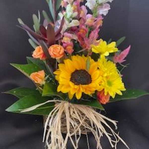 Bouquet with sunflowers, orange roses, and tall snapdragons in a basket