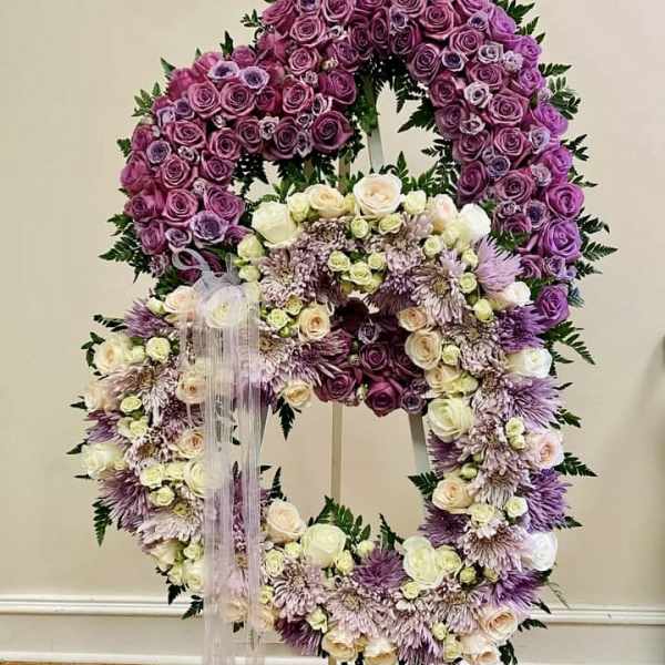 Large floral wreath on an easel with purple and white flowers