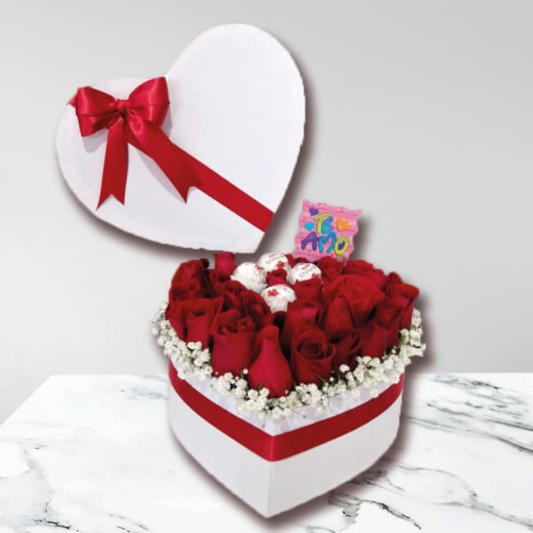 Heart-shaped box of red roses with chocolates and a red ribbon