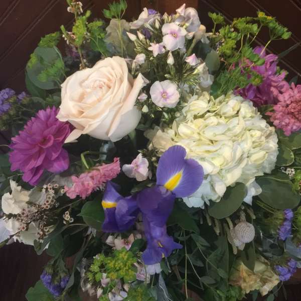 Mixed bouquet with a cream rose, purple iris, and pale hydrangea