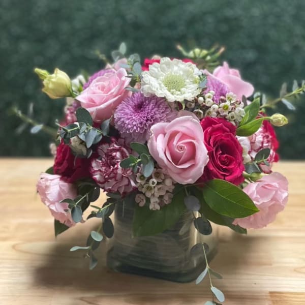 Pink and white mixed flower arrangement in a glass vase