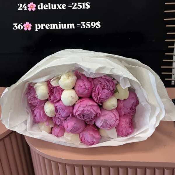 Bouquet of pink and white peonies wrapped in white paper