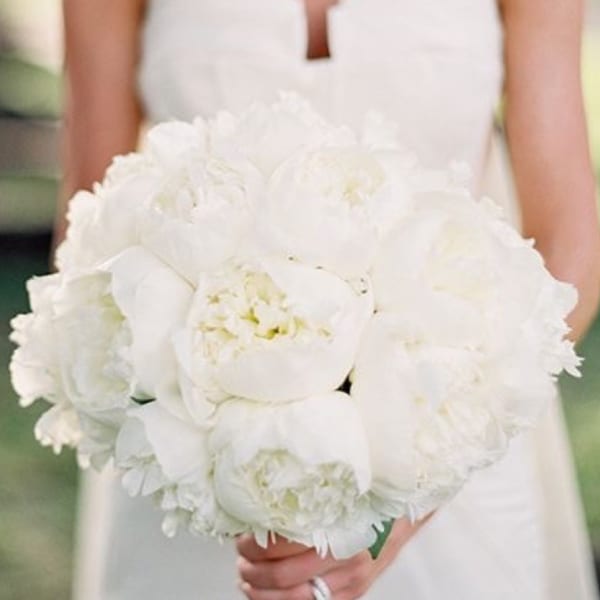 Bride holding a white bouquet of peonies