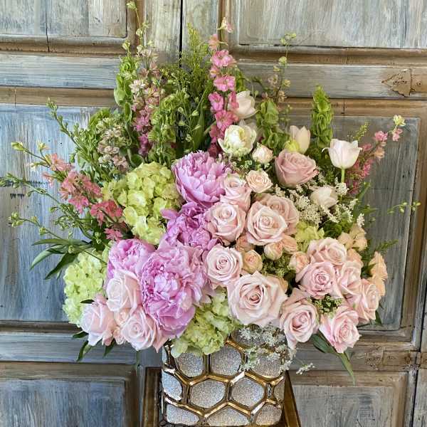 Pink and green floral arrangement in a glittery gold vase