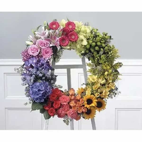 Colorful floral wreath on a stand with roses, hydrangeas, and sunflowers
