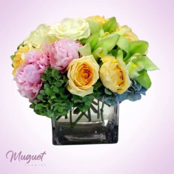 Bouquet of pastel flowers in a square glass vase