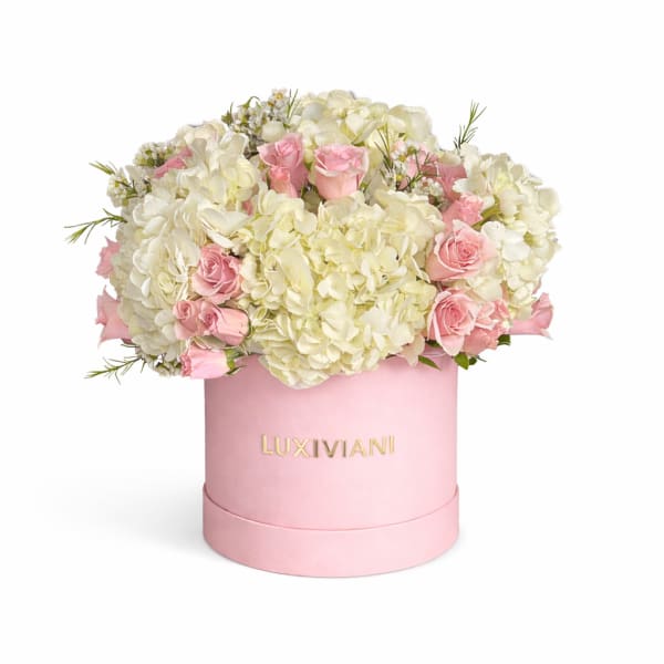 Pink roses and white hydrangeas in a pink round box
