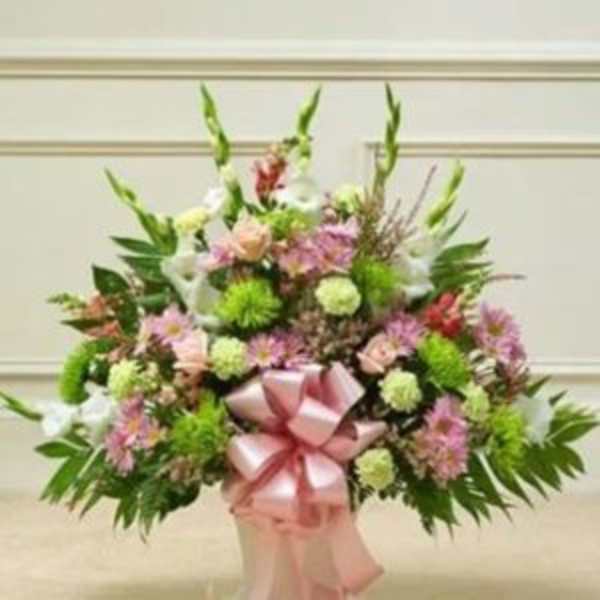 Large pastel floral standing arrangement with a pink ribbon bow