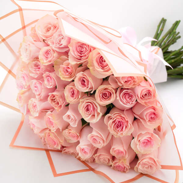 Bouquet of pale pink roses wrapped in white and peach paper