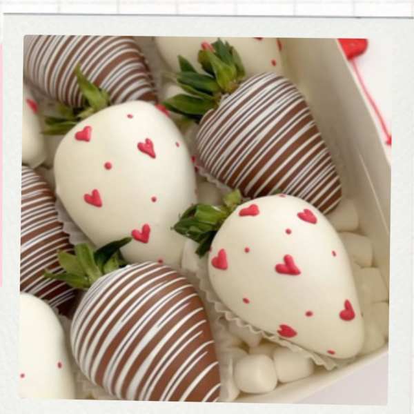 Box of chocolate-covered strawberries with heart decorations