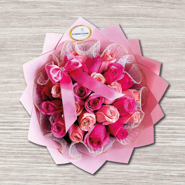 Pink rose bouquet wrapped in layered pink paper with a ribbon bow