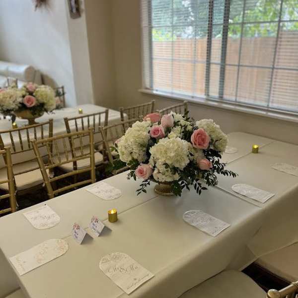 Pink and white floral centerpieces on a decorated banquet table