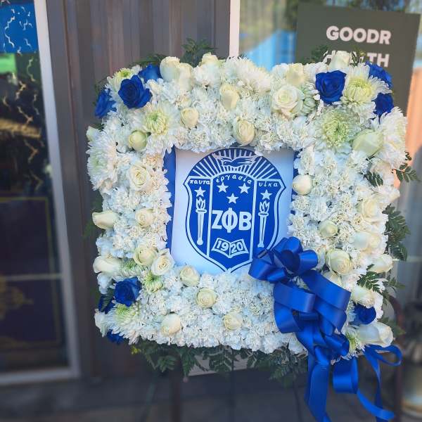 Square floral wreath with white and blue flowers around a Greek crest