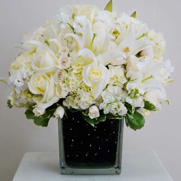 White floral arrangement in a square glass vase