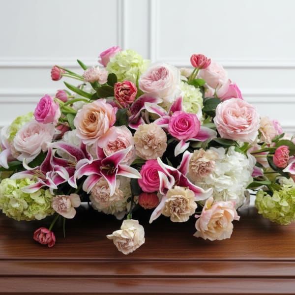 Low floral arrangement of pink and white roses with lilies and green hydrangeas