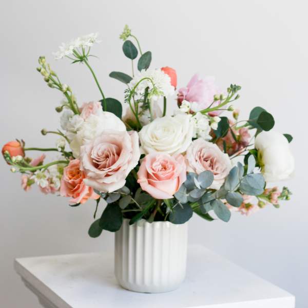 Blush and white rose bouquet in a white ribbed vase