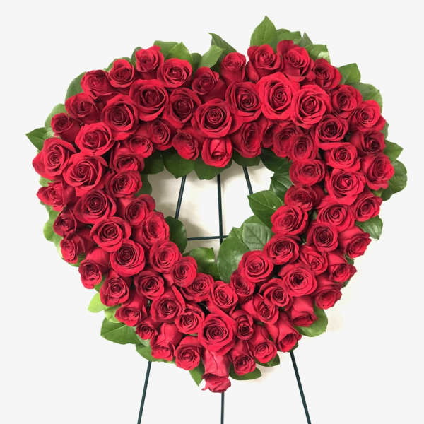 Heart-shaped wreath of red roses on a stand