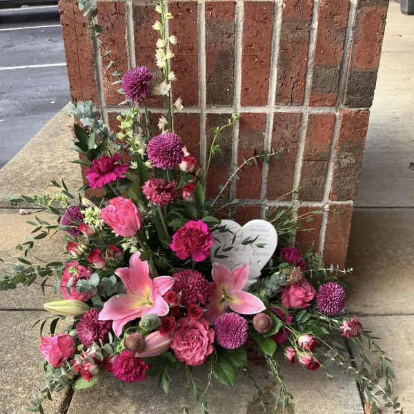 Pink and purple floral sympathy arrangement with lilies and roses