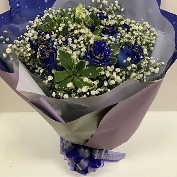 Blue roses with baby's breath in purple wrapping