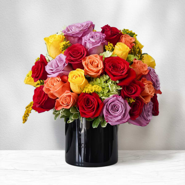 Mixed roses in red, pink, yellow, and peach in a black vase