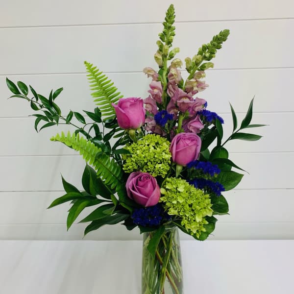 Pink roses and green hydrangeas in a clear glass vase