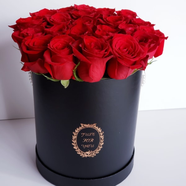 Red roses arranged in a black round box
