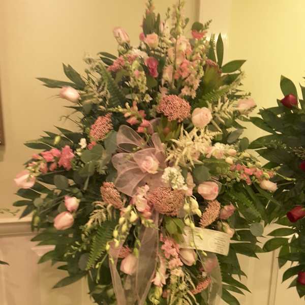 Large pink and white floral standing spray on an easel