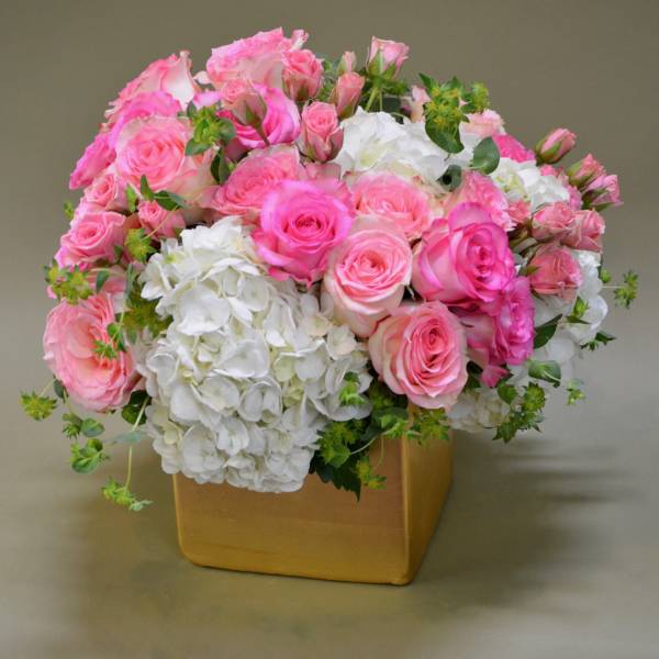 Pink roses and white hydrangeas in a gold square vase