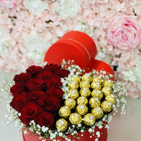 Heart-shaped box with red roses and gold-wrapped chocolates