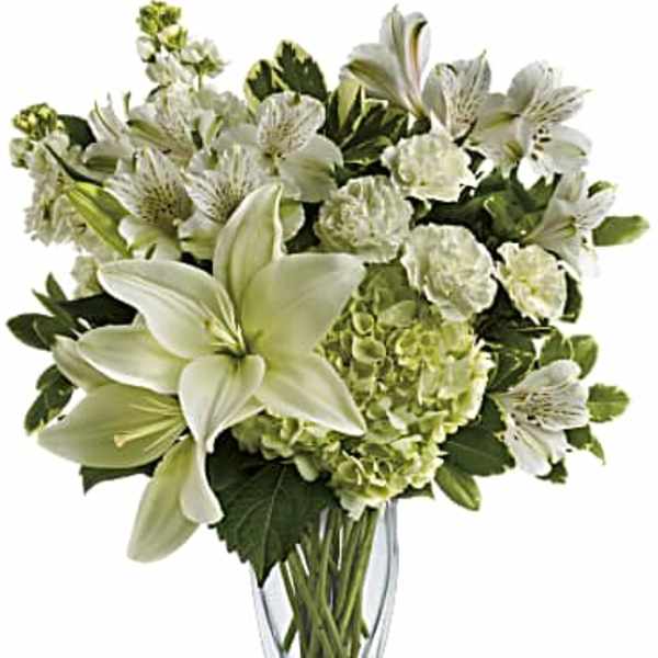 White lilies and green hydrangeas in a clear glass vase
