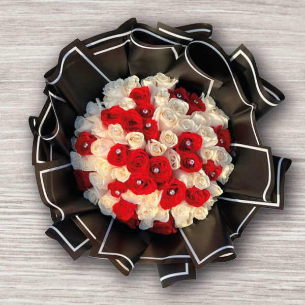 Bouquet of red and white roses wrapped in black paper