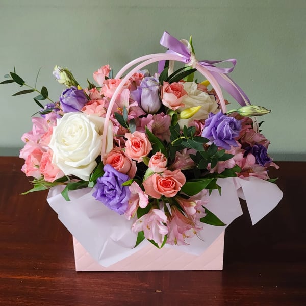 Pastel bouquet of roses and lisianthus in a pink gift box with ribbon handle