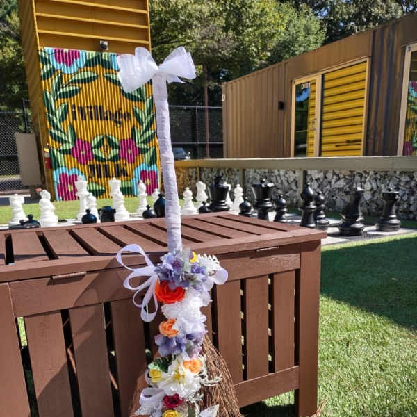Flower garland wrapped around a tall white ribboned pole