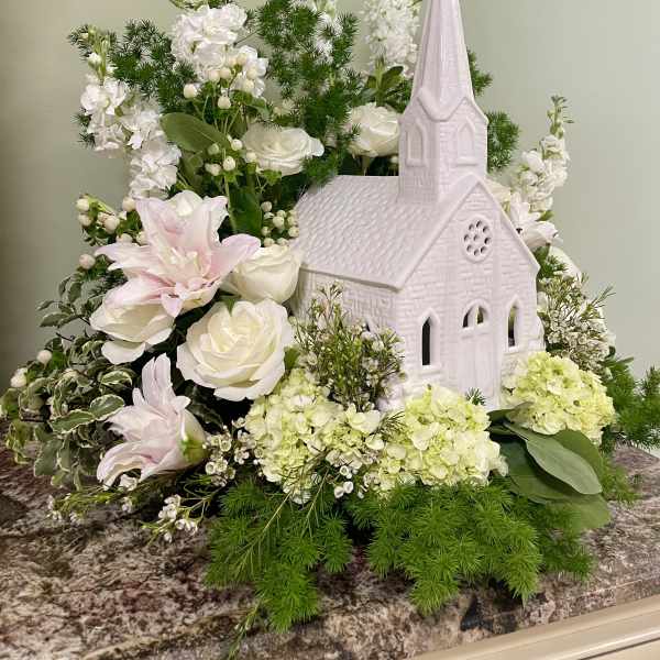 White floral arrangement with a pink church centerpiece