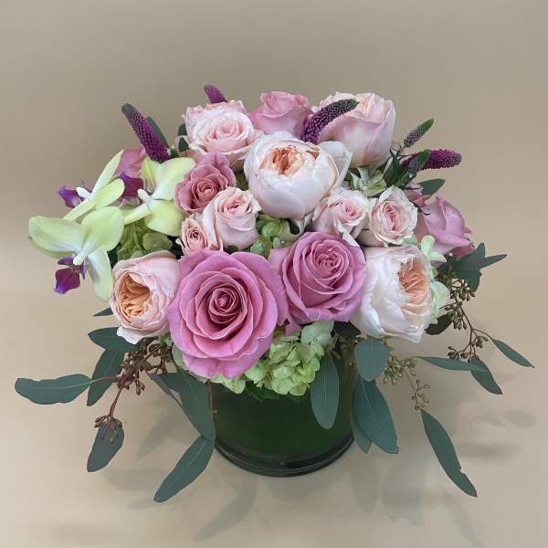 Pink and white rose arrangement in a dark vase