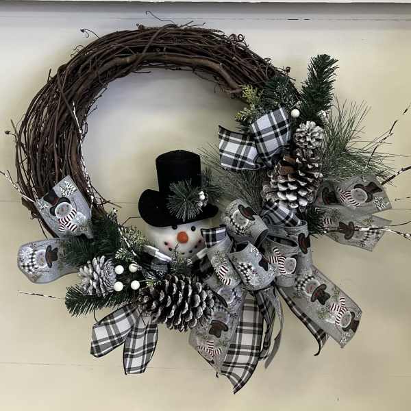 Christmas wreath with a snowman, pinecones, and plaid ribbon