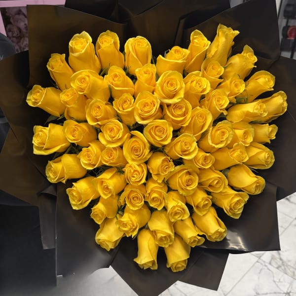 Bouquet of yellow roses wrapped in black paper
