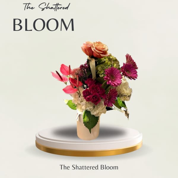 Mixed bouquet in a beige vase with pink and peach blooms