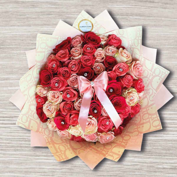 Round bouquet of red and pink roses with a satin bow