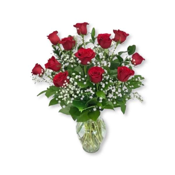 Red roses in a clear glass vase with white filler flowers