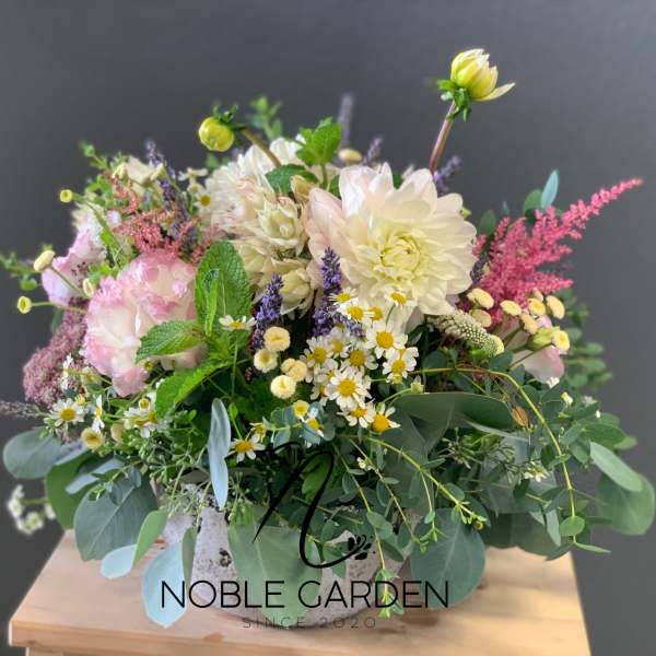 Mixed pastel flower arrangement in a white vase