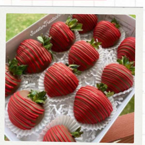 Box of chocolate-covered strawberries with red drizzle