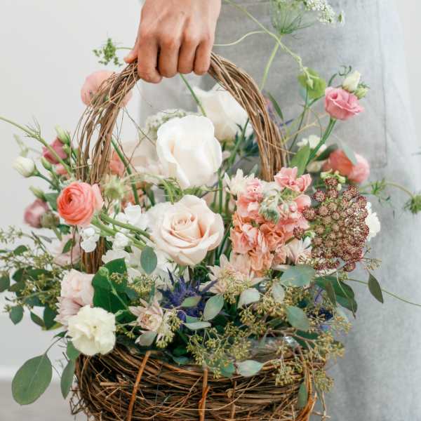 Basket of pastel flowers with roses and carnations