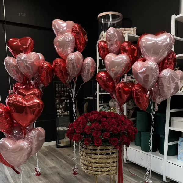 Red rose arrangement with pink and red heart balloons