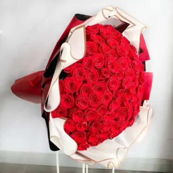 Large bouquet of red roses wrapped in white and red paper